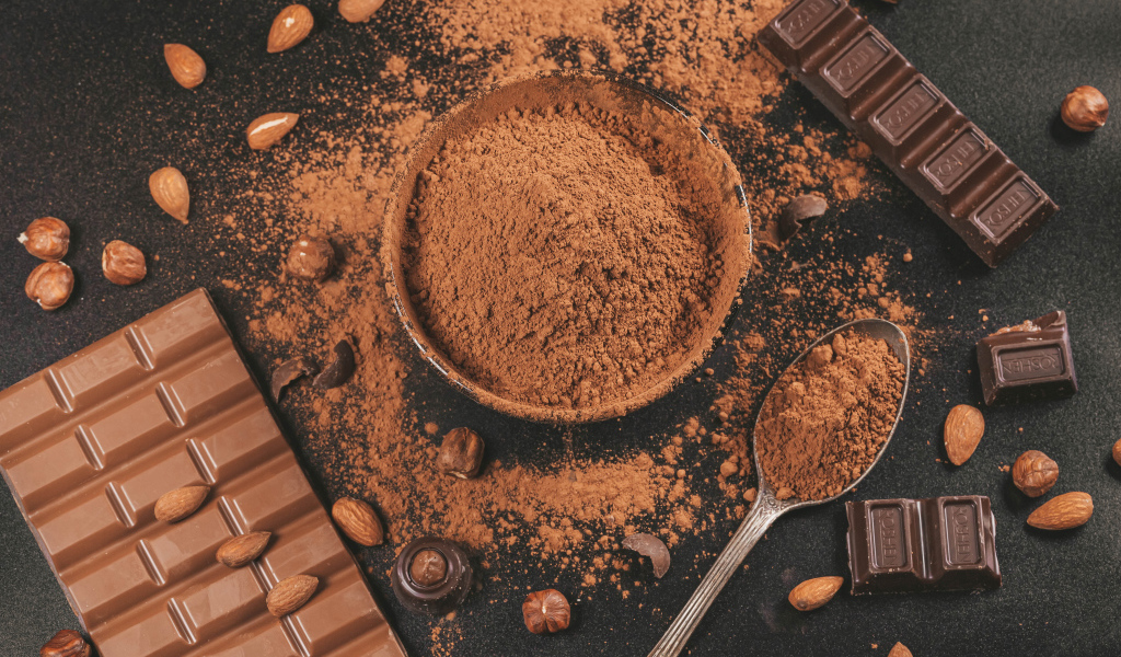 Какао на столе с орехами и плитками шоколада