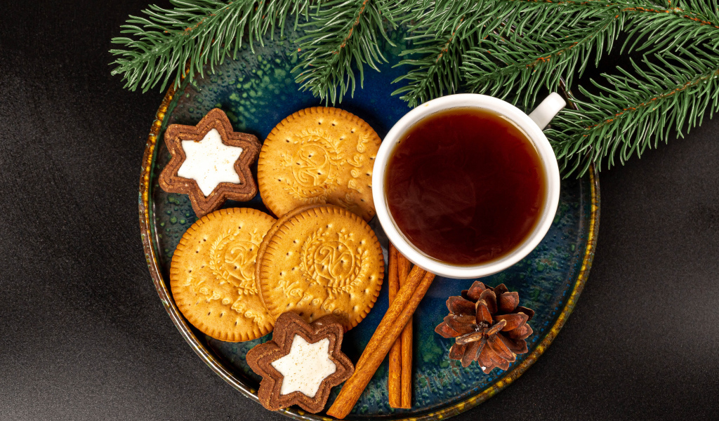 Печенье, чай и корица на столе с еловой веткой