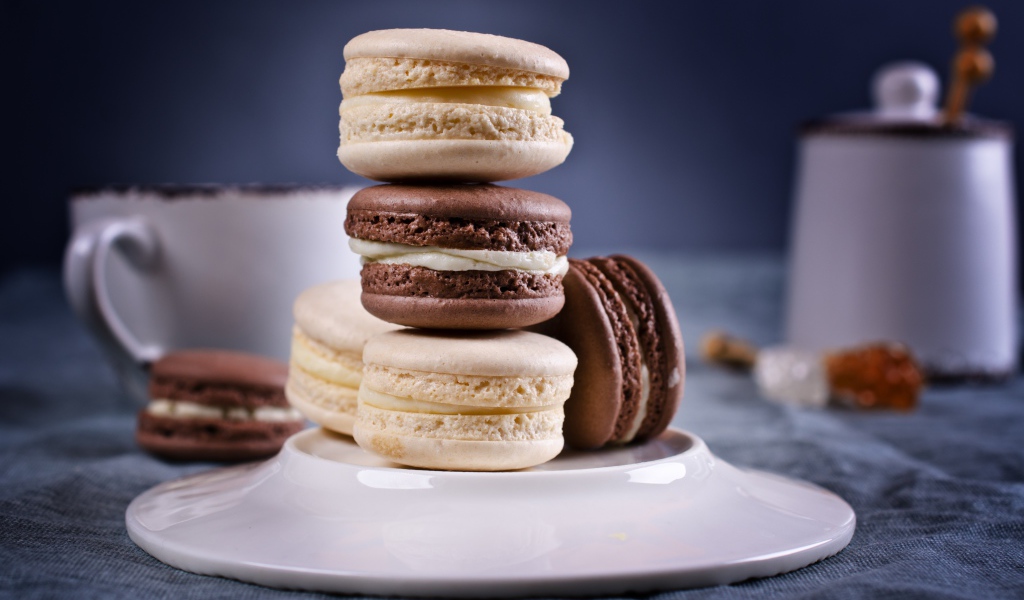 Сливочный и шоколадный десерт макарун на столе с тарелкой