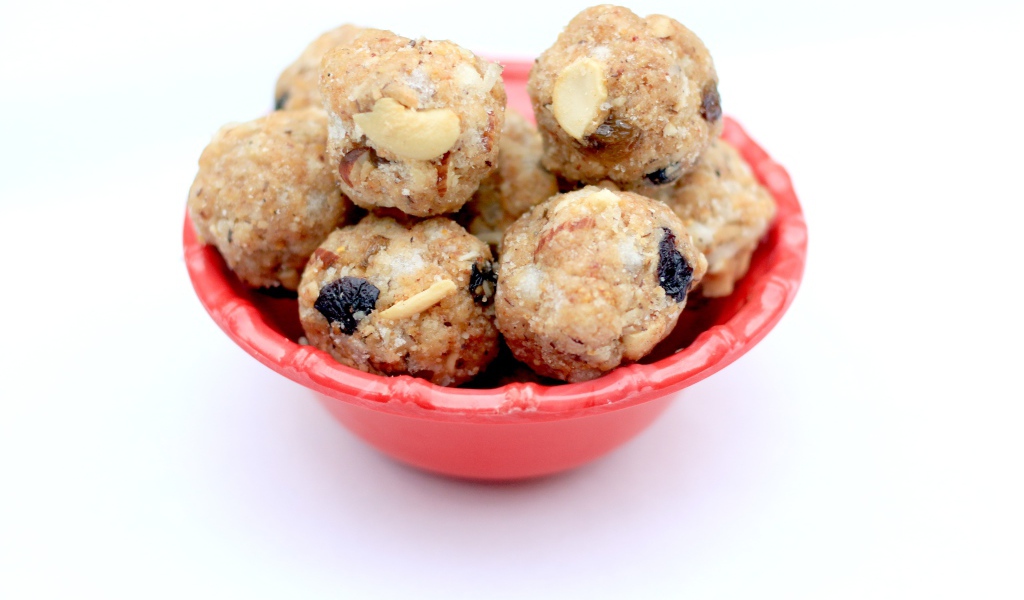 Десерт ладду в красной миске на сером фоне