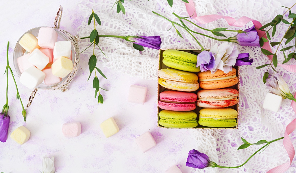 Десерт макарон на столе с кружевной салфеткой и маршмеллоу