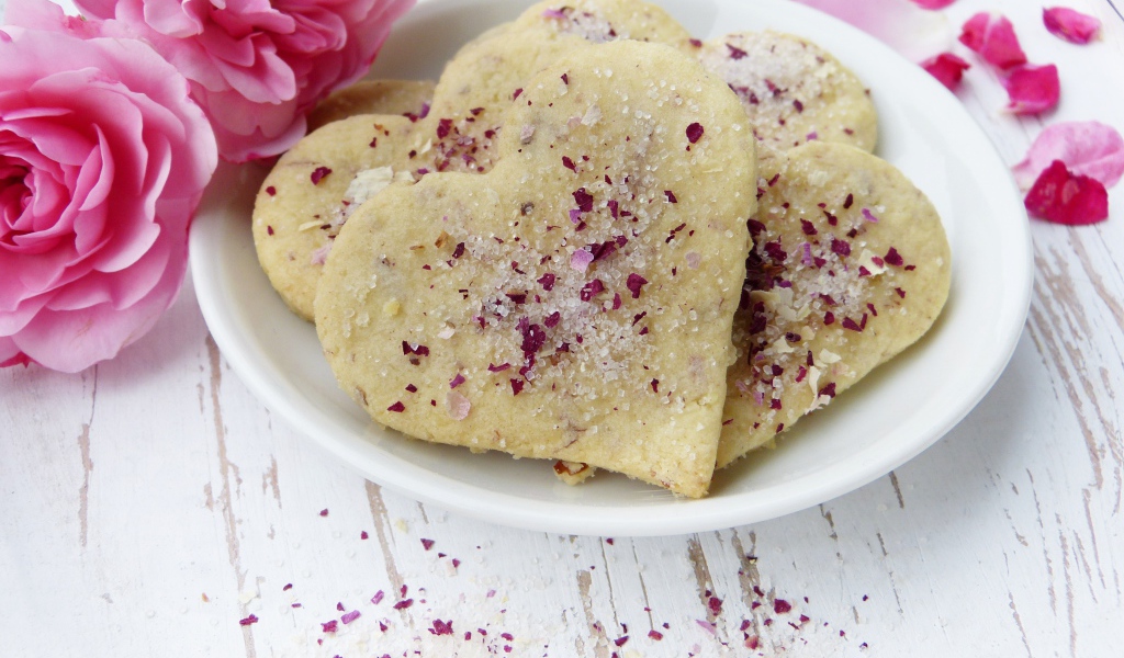 Песочное печенье в форме сердца в белой тарелке с цветами