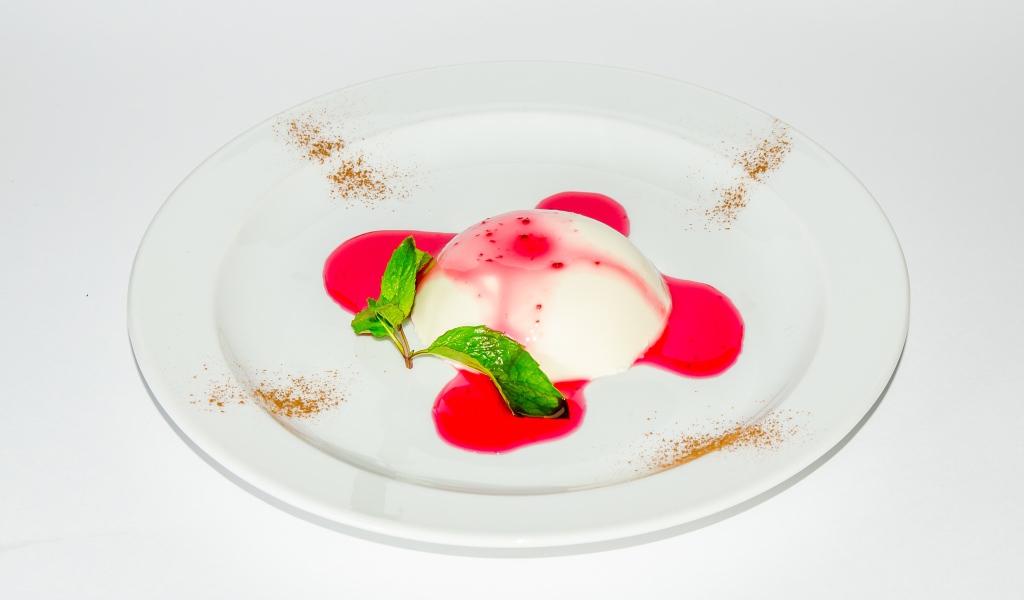 Молочное желе с джемом на белой тарелке 