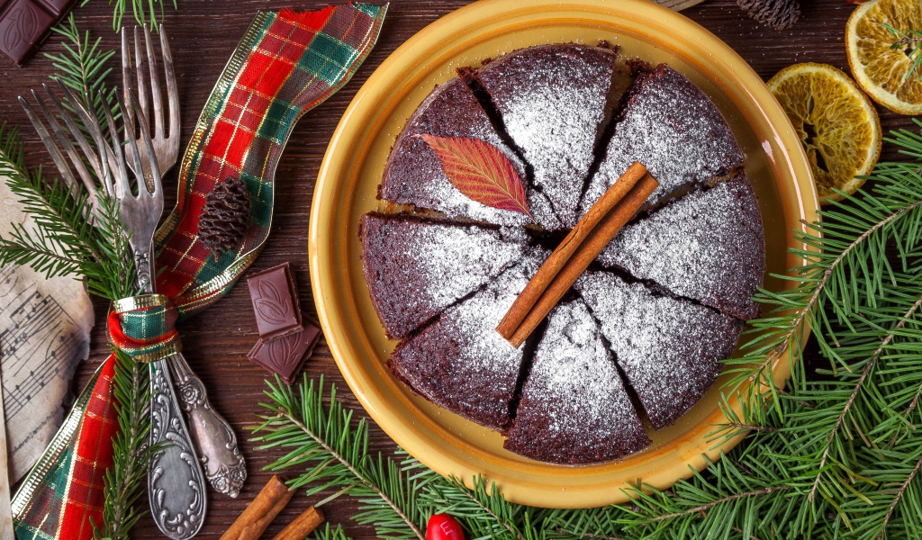 Пирог с сахарной пудрой на столе со столовыми приборами