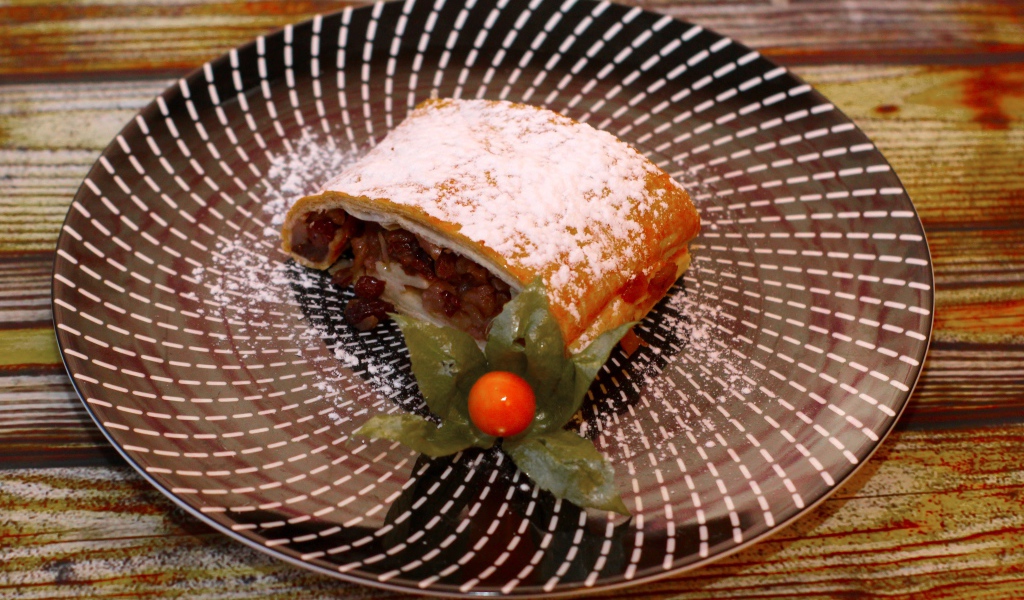 Кусок яблочного штруделя на тарелке 