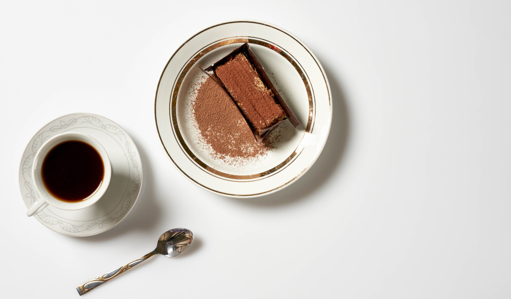 Кусок торта на столе с чашкой кофе 