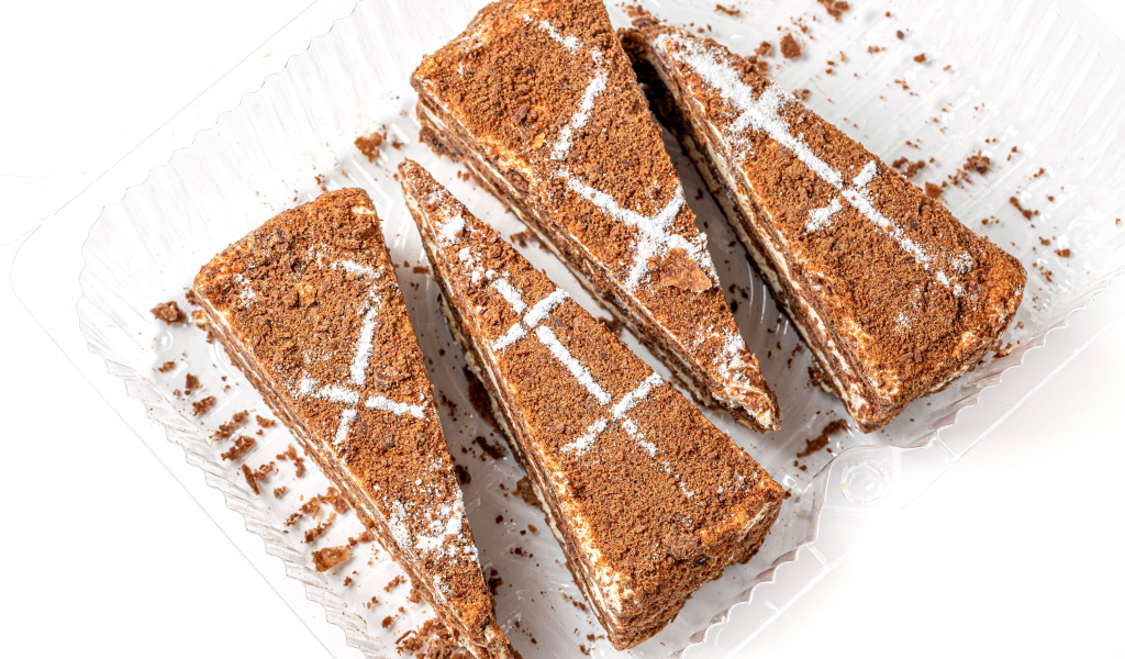 Куски аппетитного медового торта на белом фоне