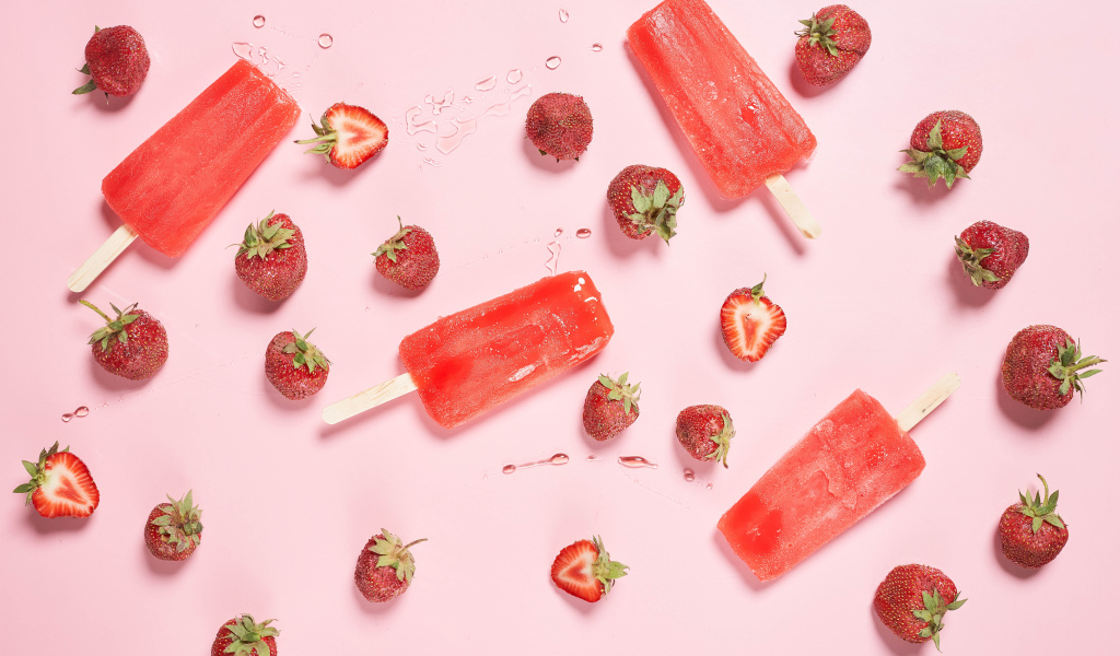 Фруктовое мороженое на розовом фоне с ягодами клубники 