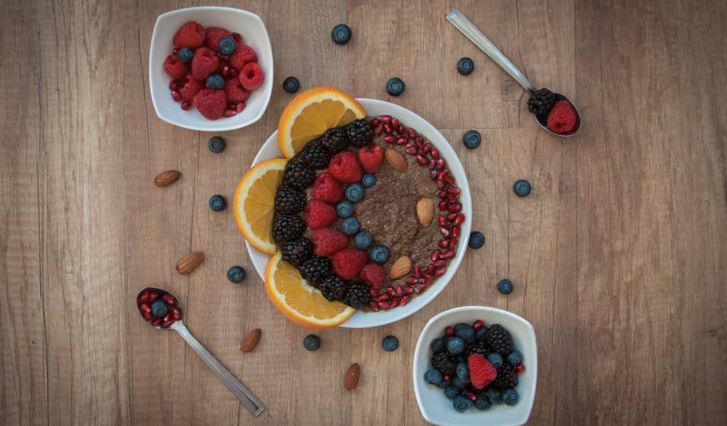 Каша с ягодами в тарелке на столе на завтрак