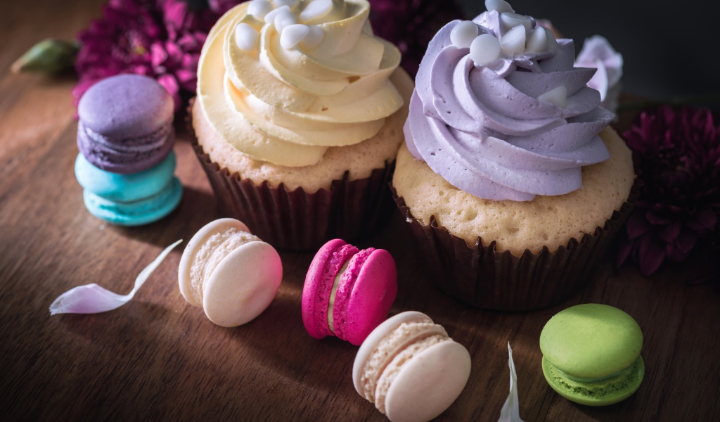 Два капкейка на столе с десертом макарун