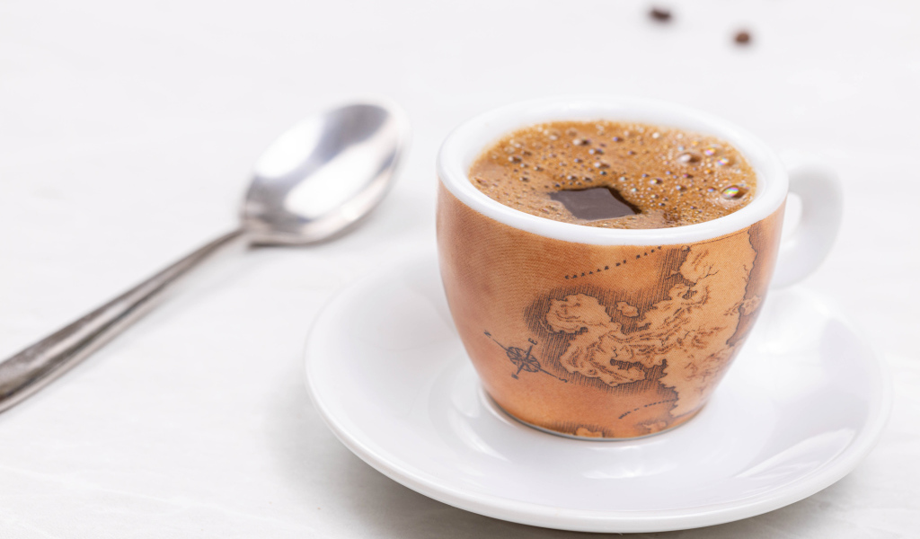 Чашка горячего кофе на столе с ложкой