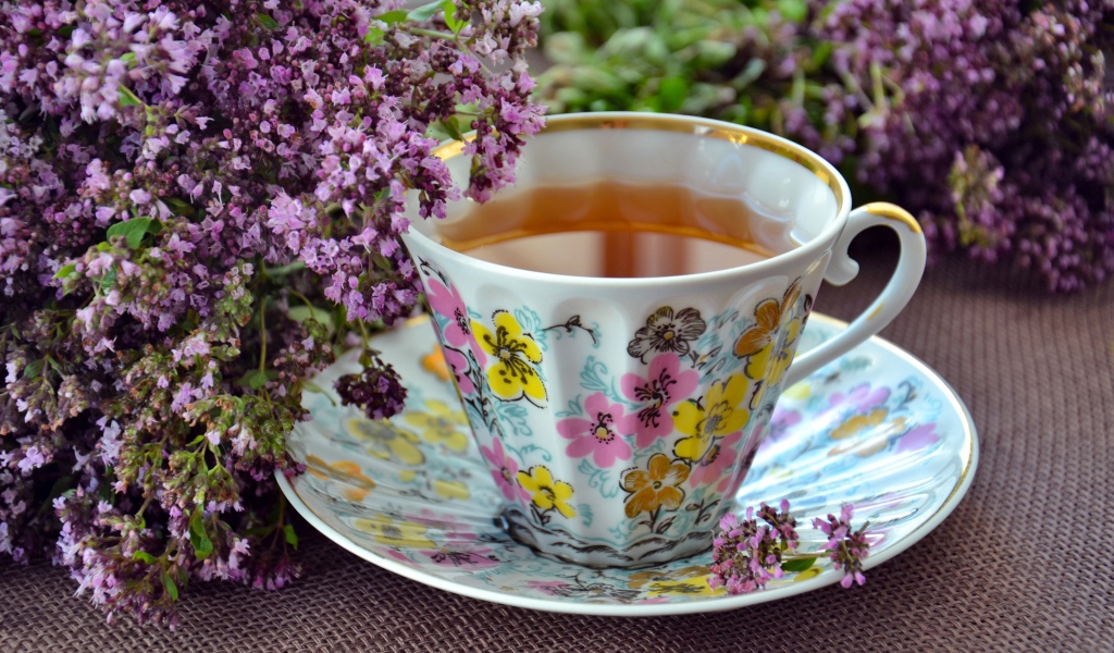 Чашка чая с цветами мяты на столе