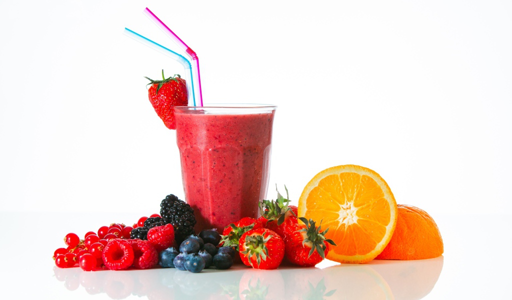 Стакан свежего смузи на столе с ягодами