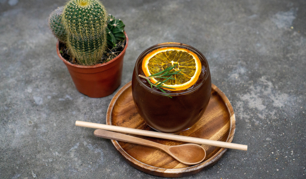 Чай с лимоном на столе с колючим кактусом