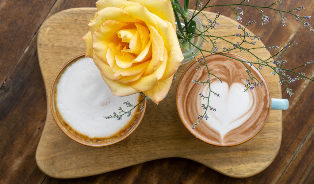 Две чашки капучино на столе с розой