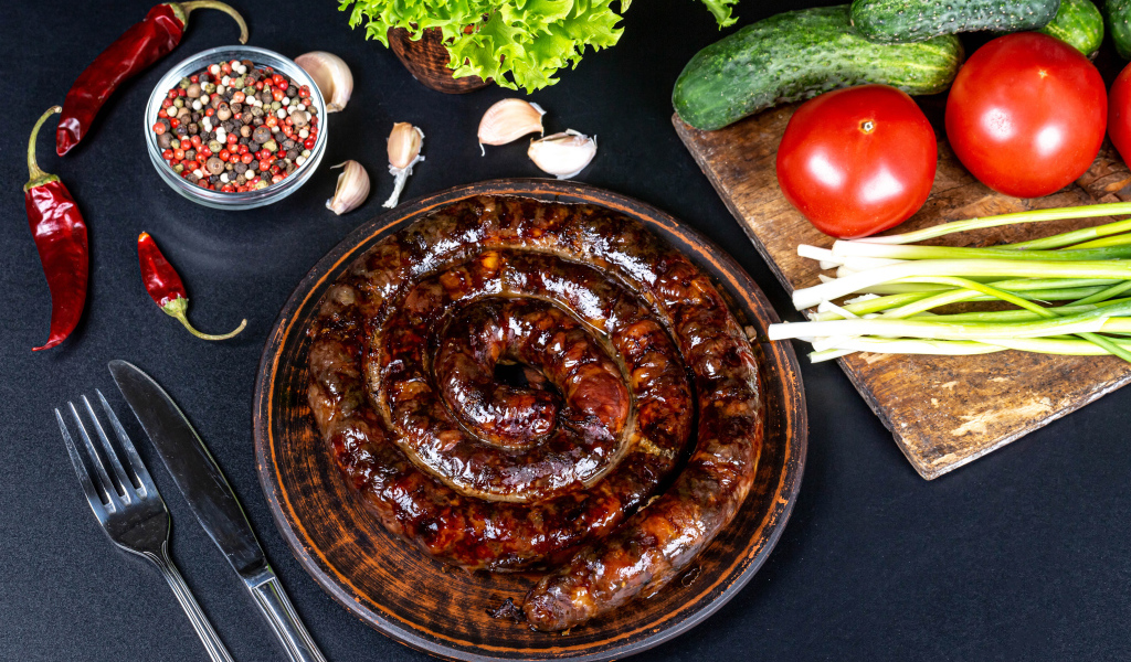 Appetizing homemade sausage on the table with spices and vegetables