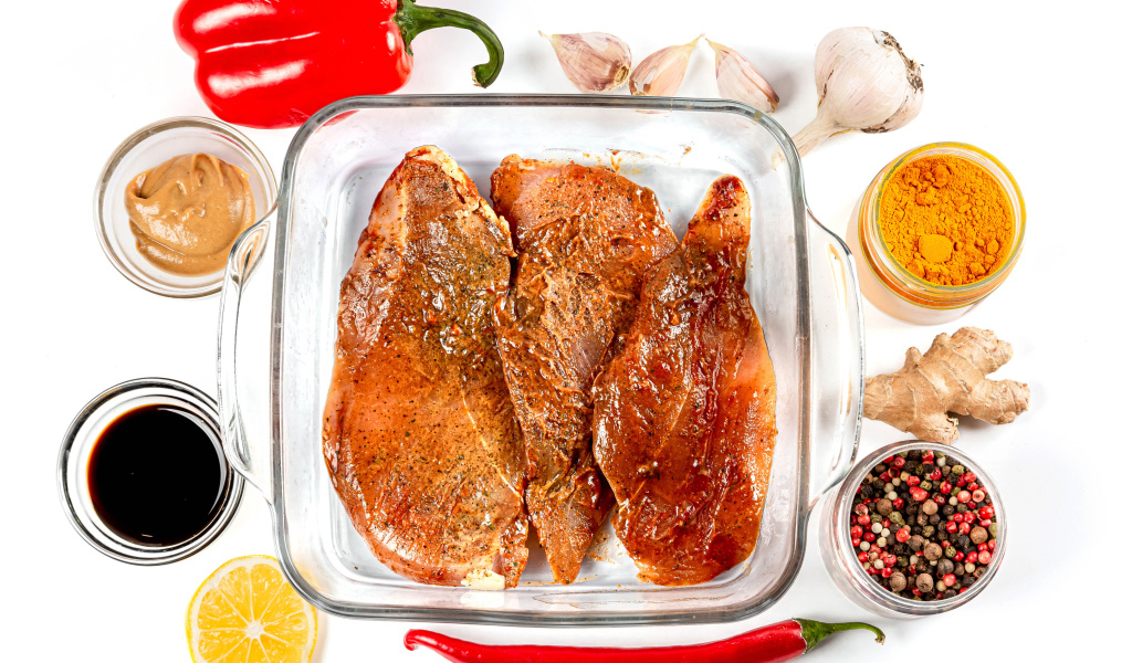 Маринованное мясо на столе со специями и соусом