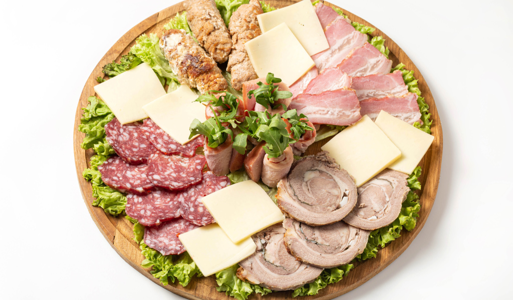 Мясные продукты с сыром на доске на белом фоне
