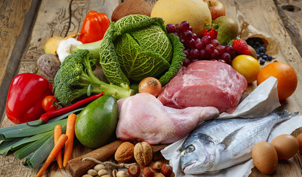 Мясо с рыбой на столе с овощами и фруктами 