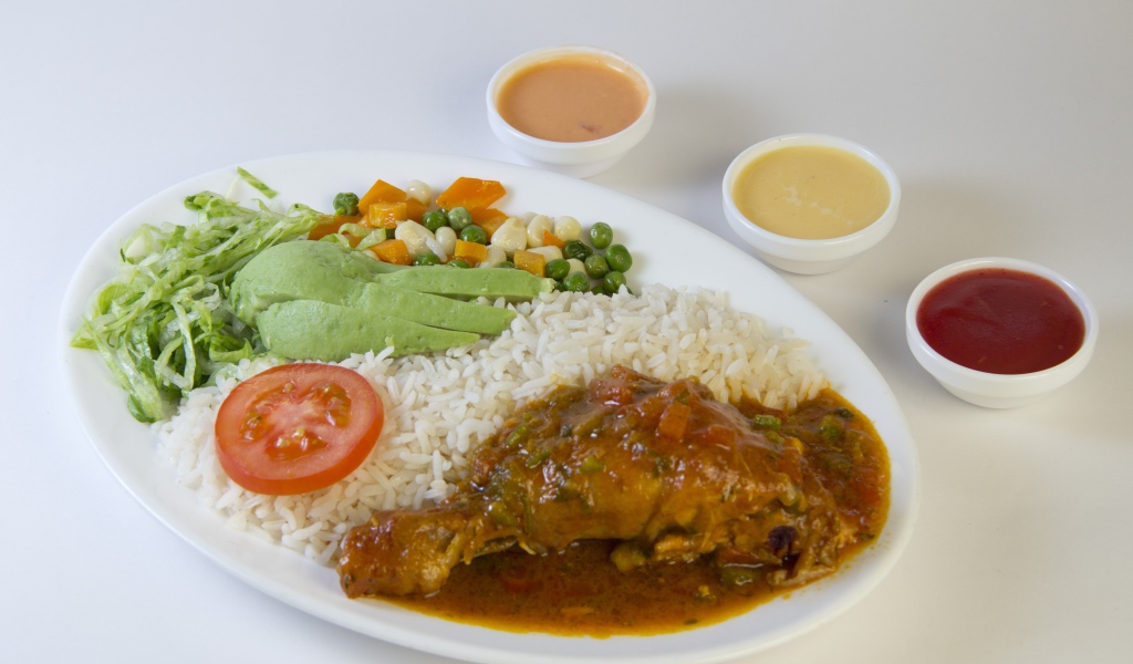 Rice with chicken and vegetables on the table with sauce