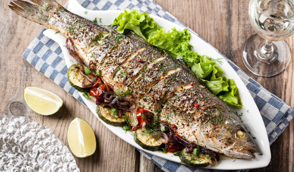 Большая запеченная рыба с кабачками и листьями салата