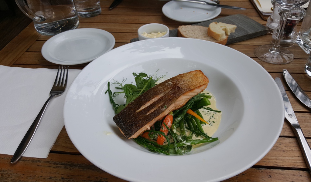 Кусок красной рыбы с овощами на столе в ресторане