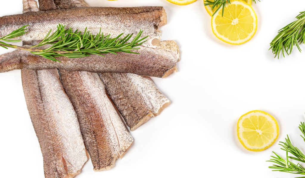 Сырая рыба с розмарином и лимоном на белом фоне