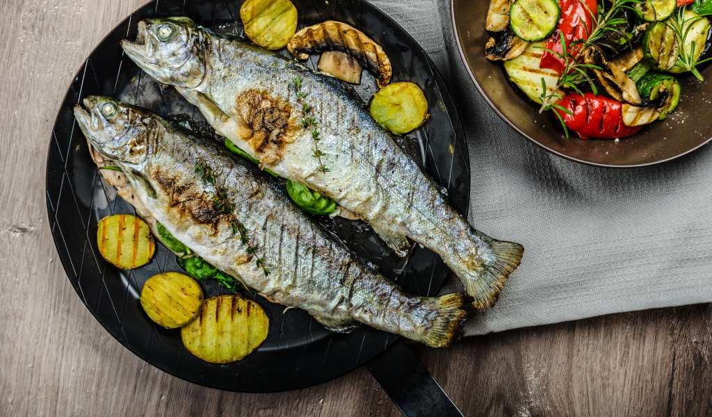 Две рыбины на сковороде с овощами