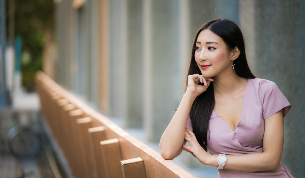 Красива девушка азиатка задумчиво смотрит вдаль