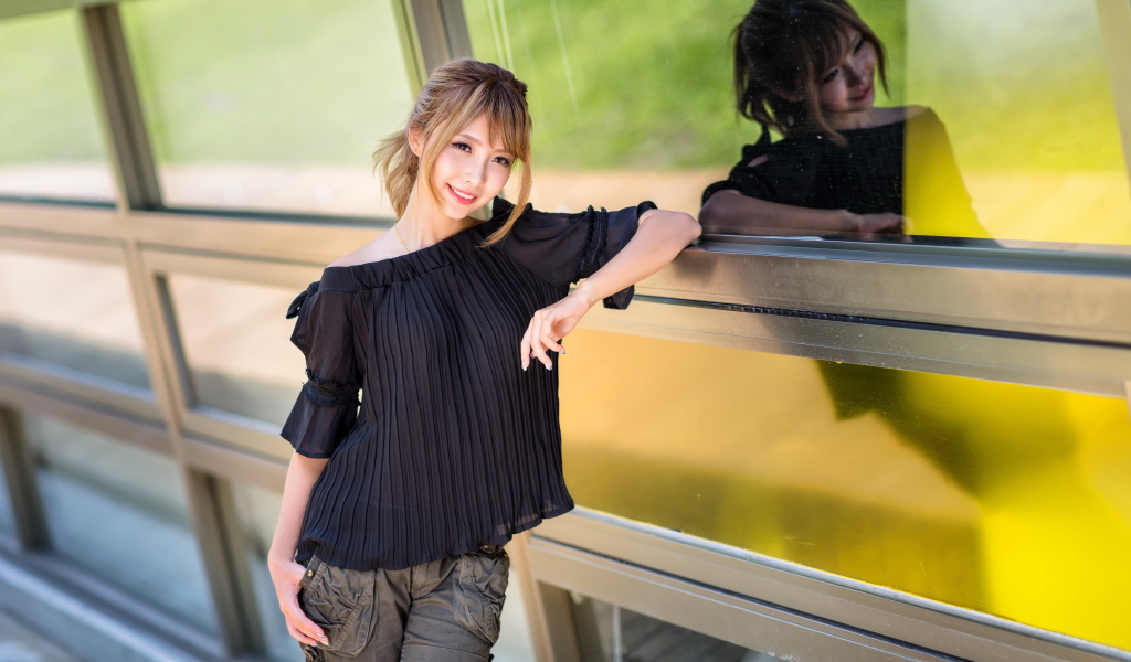 Девушка азиатка в черной блузке у окна