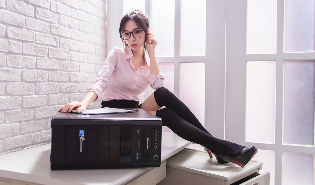 Девушка азиатка в черных чулках с системным блоком