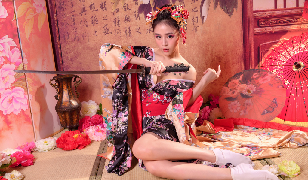 Девушка азиатка в кимоно с мечом сидит на полу 