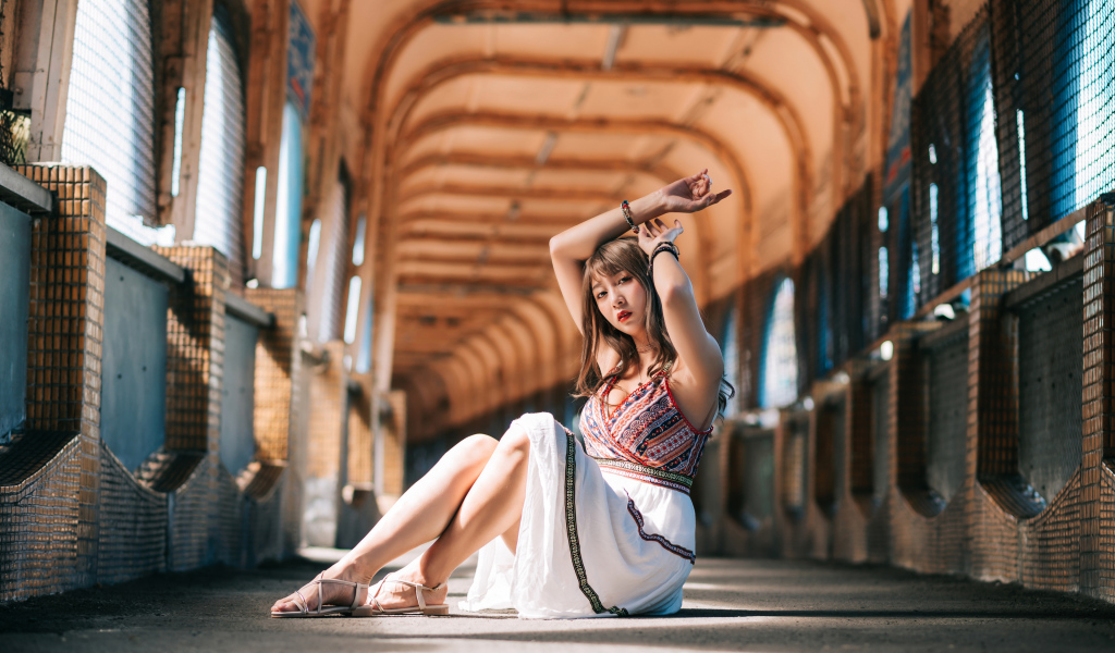 Девушка азиатка сидит в переходе 