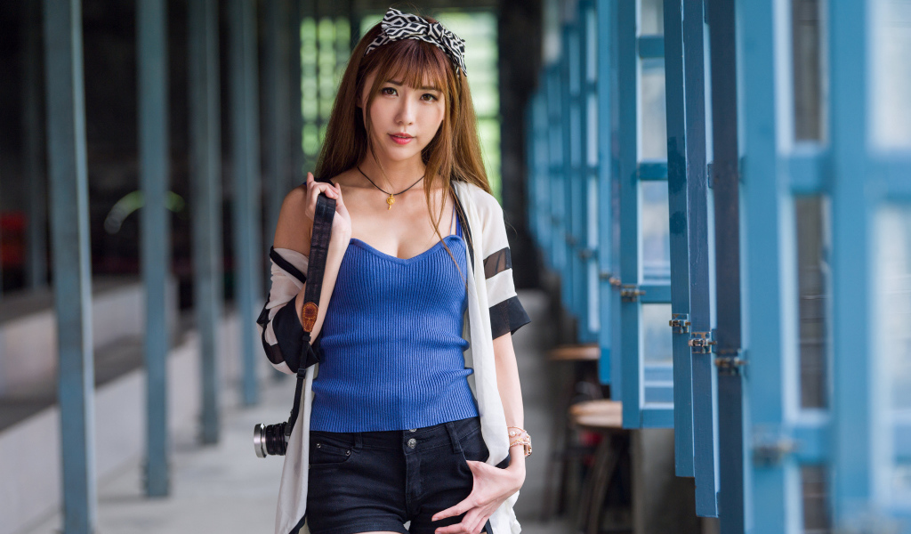 Девушка азиатка с фотоаппаратом в руках 