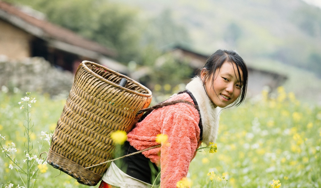 Девушка азиатка с корзиной на поле 