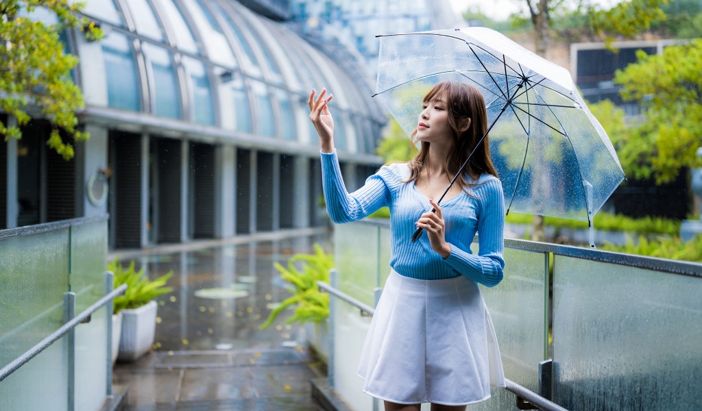 Девушка азиатка с зонтом под дождем