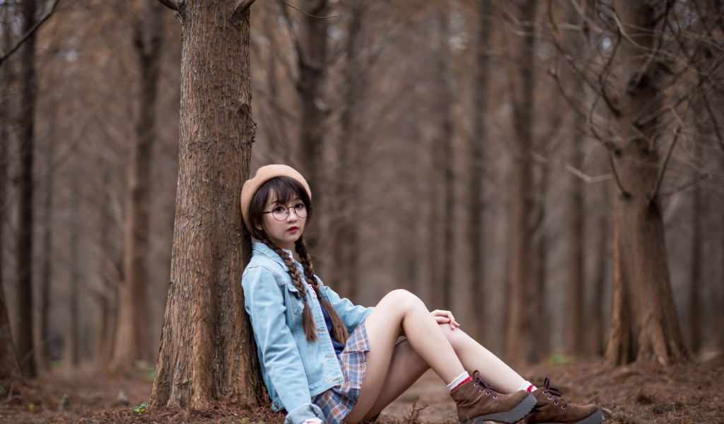 Девушка азиатка школьница сидит под деревом