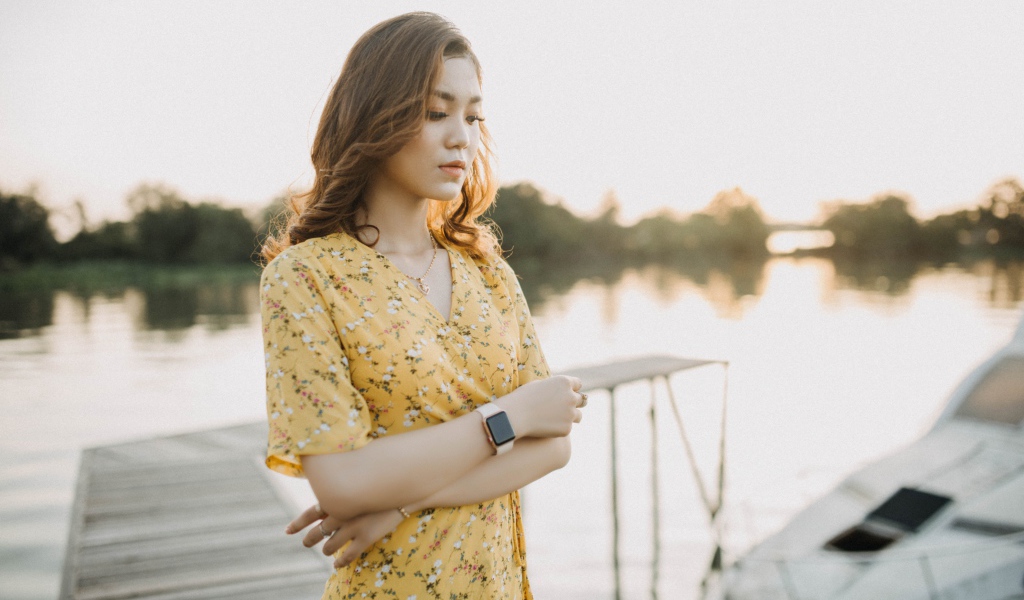 Красивая девушка азиатка стоит у реки 