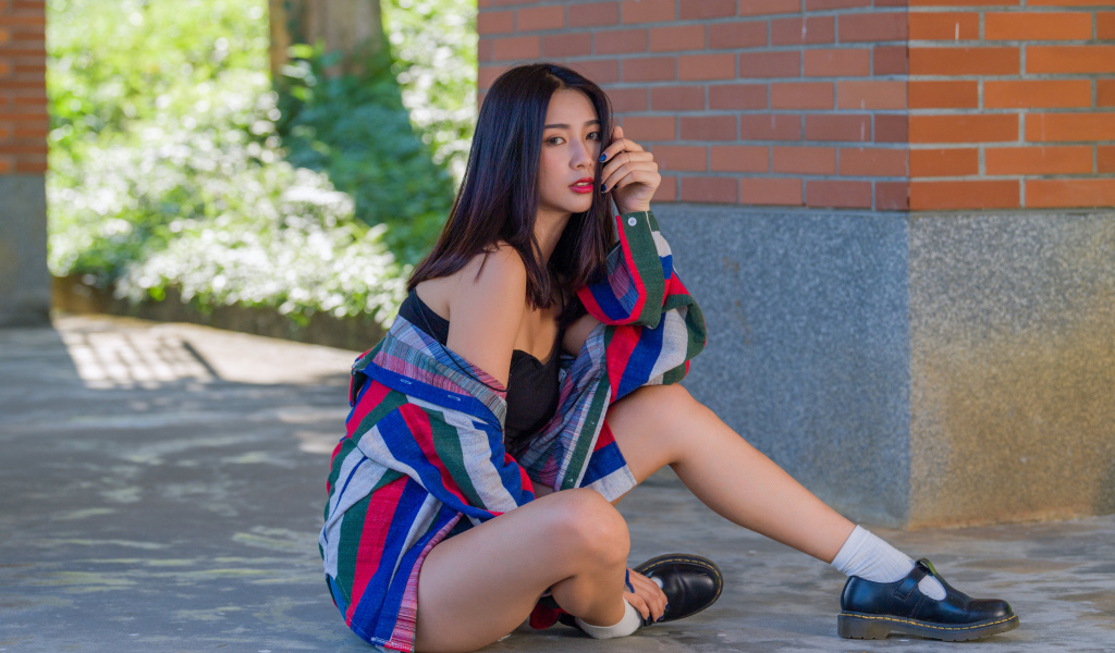 Красивая азиатка в рубашке у стены