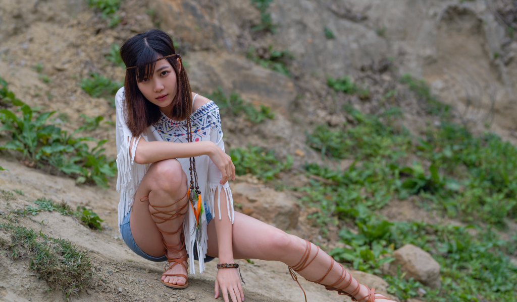 Красивая девушка азиатка сидит на земле  в туфлях