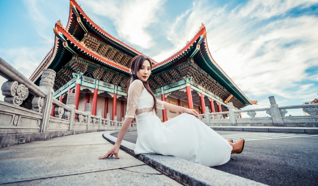 Красивая азиатка в белом платье на фоне храма