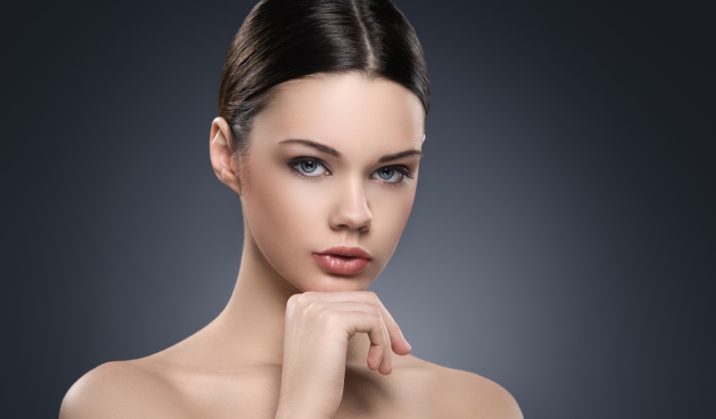 Красивая голубоглазая девушка на сером фоне 