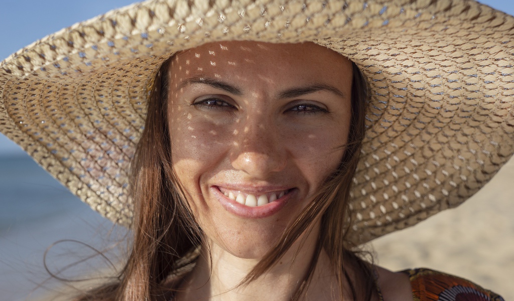 Красивая кареглазая девушка в большой соломенной шляпе 