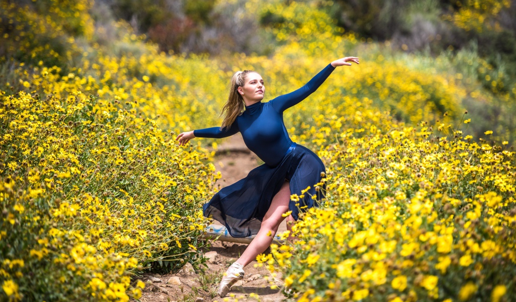 Красивая девушка балерина на поле с желтыми цветами