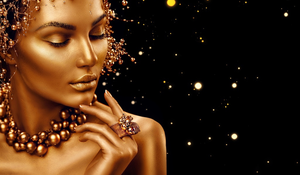 Красивая девушка в золотой краске на черном фоне