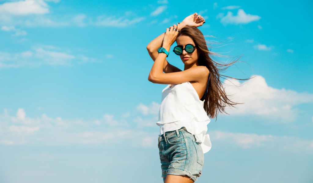 Красивая девушка в шортах на фоне неба