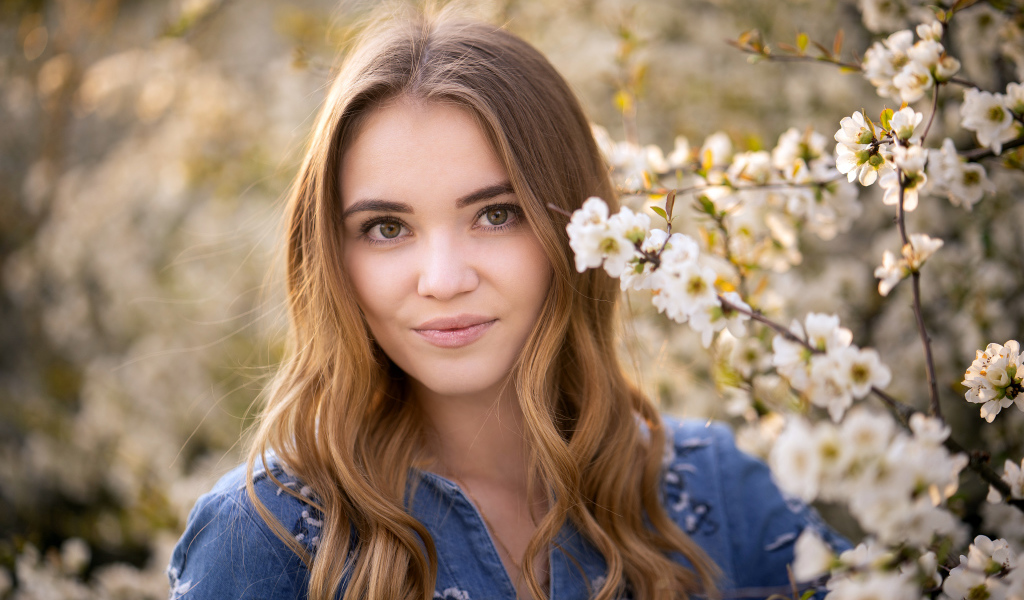 Красивая девушка у ветки с белыми цветами
