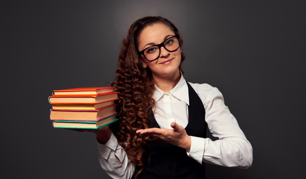 Красивая девушка учитель в очках с книгами в руке
