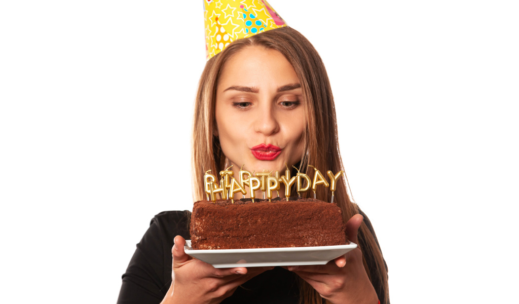 Красивая девушка с тортом на день рождения на белом фоне 