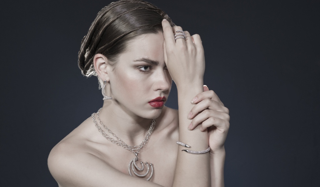 Красивая девушка с украшениями на теле на сером фоне